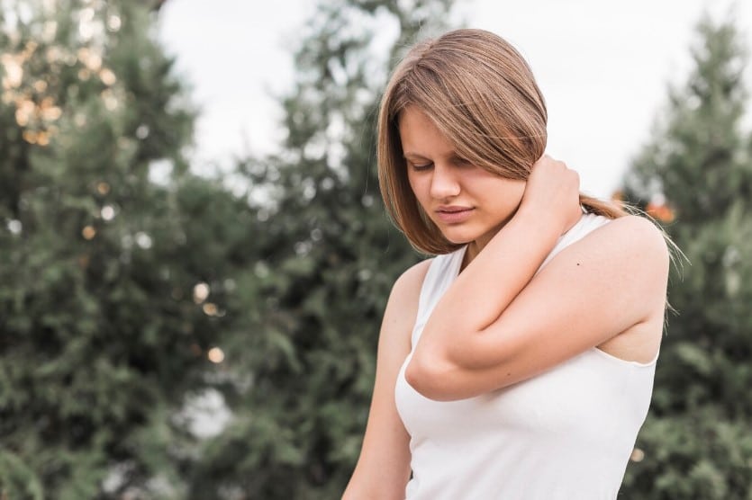 chica joven rubia con dolor de cuello